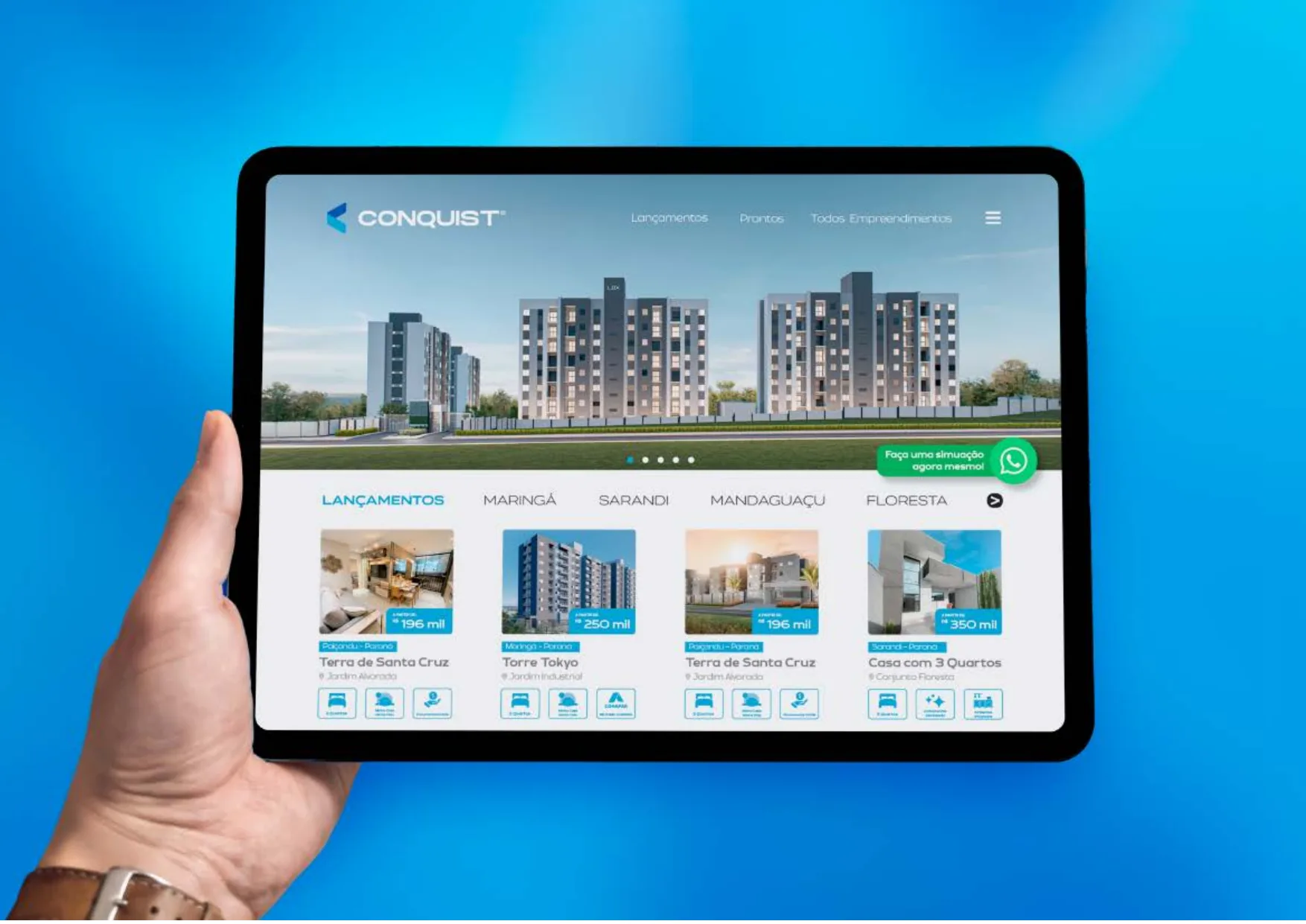 Tablet exibindo o site da Conquist com vitrine de lançamentos por cidade.